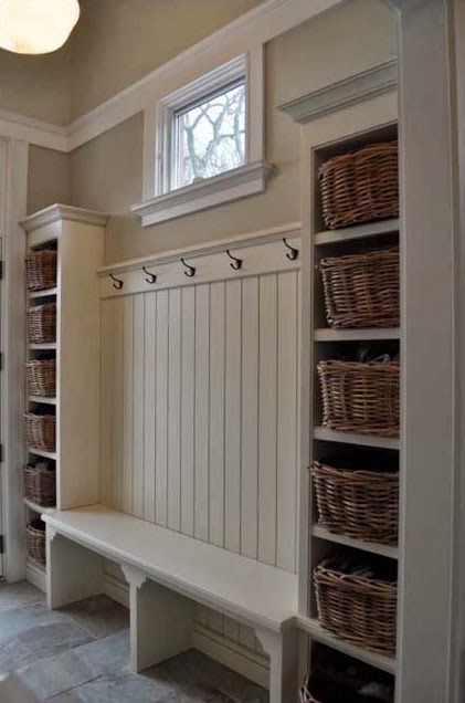 Love this mudroom foyer idea for keeping everything neat and decluttered - the white wall is gorgeous and the baskets make it easy to stay organized and neat.