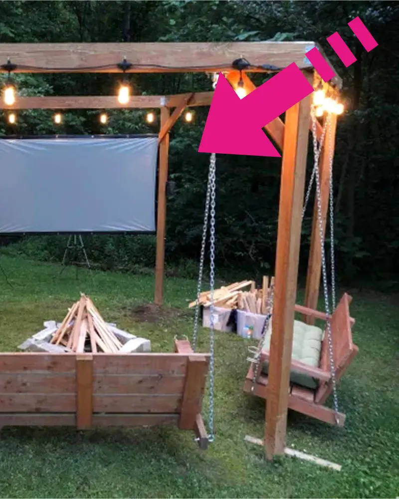 fire pit DIY swing seating ideas - unique homemade fire pit with porch swings and movie screen in the backyard