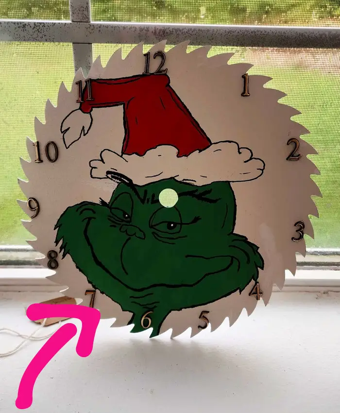 diy Grinch christmas decoration made from old saw blade turned into a clock