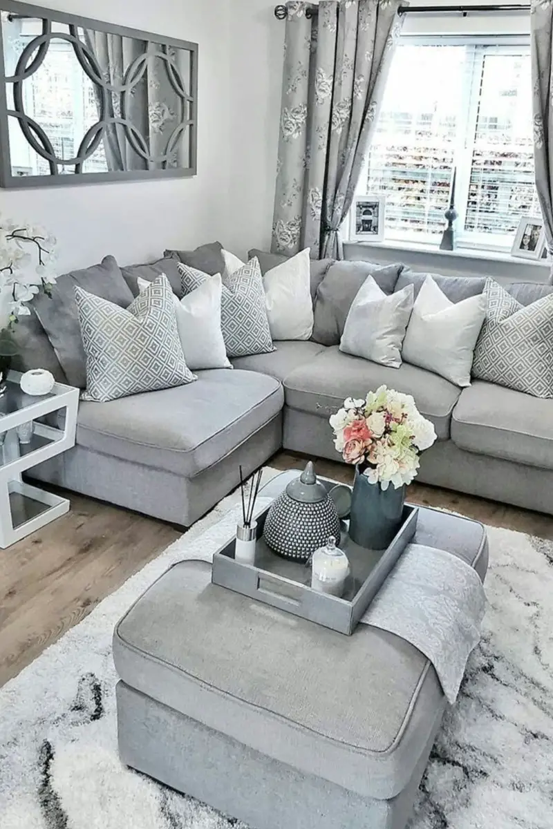 Cozy neutral grey living room light grey sectional couch grey back white area rug throw pills and pops of color decor